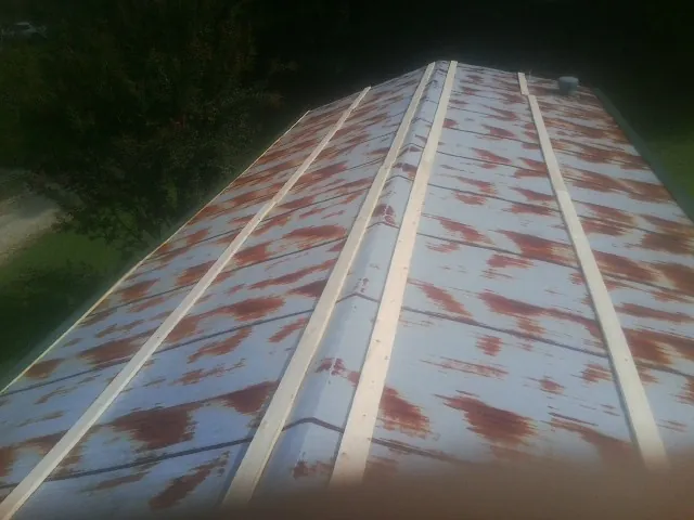 Rusted metal roof panels with new wood purlins before replacement — Storm Damage Roof Repair in Kennebunk by Roofing Brothers