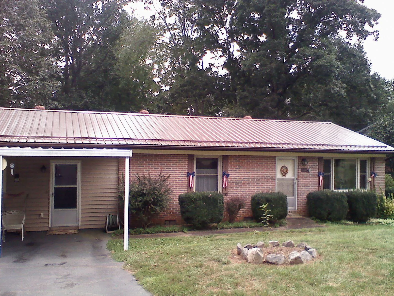 Bronze metal roof and carport on a brick ranch home — Roof Repair work by our crew in Kennebunk